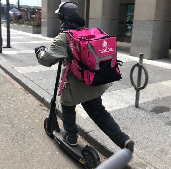 person delivering food on an electric scooter